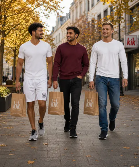 Tres hombres con looks deportivos y otoñales y bolsas de KiK paseando por la ciudad